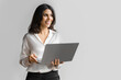 © Stock 4 You - Young middle eastern businesswoman using laptop pc ai application for work isolated on white wall. Indian or arabic woman it specialist in business clothes holding computer, doing data base research