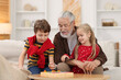 © New Africa - Grandpa and his grandkids playing with math game Times table tray at home