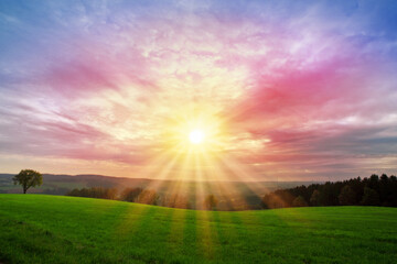 Wall Mural - Colorful sunset background with sun and big abstract clouds.