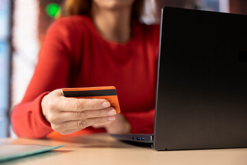 Confident person using her card to donate money to a charity organization, confirming payment details and transfer. Woman selecting a cause and making contributions for those in need.