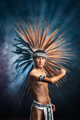 A man wearing a feather headdress and a white shirt