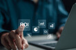© Pakin - ROI, Return on Investment concept. Businessman use laptop with ROI icon on virtual screen. Investment of some resource yielding a benefit, investment business.