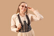 © Pixel-Shot - Stylish young woman in sunglasses with suspenders on beige background
