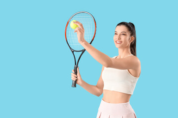 Wall Mural - Sporty young woman playing tennis on blue background