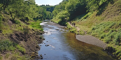 Sticker - A river with a group of people walking along it. The water is calm and the trees are lush and green