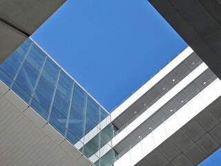 Poster - Modern architecture in Tseung Kwan O, Hong Kong, China.  A clear blue sky is visible through the geometric glass and concrete structures.
