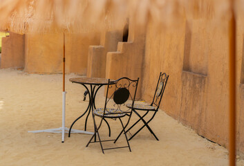 Garden chiars setting on surrounded by sand in an Arabic style cafe