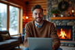 © draftseptember - a man, late 20s, sitting in a cozy mountain lodge with his laptop, a fireplace crackling in the background.