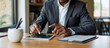 © Rick Captura - Man Sitting at Table with Tablet and Cup Enjoying His Time
