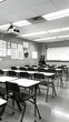 © Taufiq - Empty classroom with desks and chairs, projector, whiteboard, and educational materials. Black and white photography.