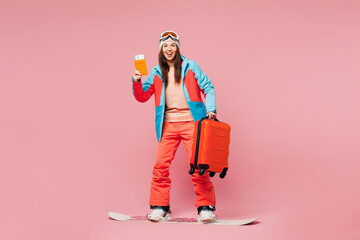 Poster - Traveler happy woman wears jacket ski goggles mask hold passport ticket bag ride snowboard isolated on plain pink background Tourist travel abroad in free time getaway Air flight trip journey concept.