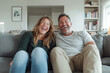 © Robert Kneschke - Joyful couple laughing together on a comfortable sofa at home