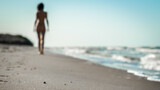 swimsuit in the sand on the beach near the sea surf on the background of a naked female figure and blue sky