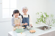 © polkadot - 料理するおばあちゃんと孫.