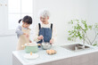 © polkadot - 料理するおばあちゃんと孫.