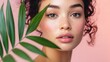 © The 2R Artificiality - Captivating portrait of a young woman with curly hair and freckles, soft pink background, showcasing skincare with green palm leaf in foreground.