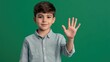 © The 2R Artificiality - Boy aged 7 showing number five with hand gesture on vibrant green background wearing light blue shirt reflecting youthful innocence and playfulness