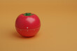 © jroballo - Tomato shaped kitchen timer isolated on orange background with copy space. Pomodoro technique concept. 3d illustration.