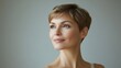 © The 2R Artificiality - Portrait of a woman with short hair looking thoughtfully to the side against a neutral background Copy Space