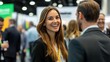 © Surachetsh - young woman with a confident smile interacts with professionals at a networking event, embodying openness and a strong networking purpose.