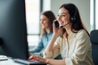 © SimpleDesignStudio - A Smiling Young Woman with a Headset Providing Customer Support in a Modern Office Setting, Engaging with Clients Through a Computer and Phone