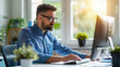 © Vilaysack - Man working at his desk in a modern office filled with natural light and greenery, representing productivity, concentration, and business efficiency.