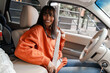 © Maria Vitkovska - Young woman fastening seat belt smiling and looking back inside car