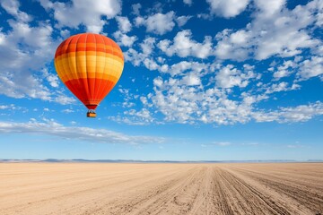 Colorful hot air balloon soaring over a vast desert landscape under a bright blue sky with clouds