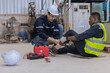 © kanpisut - First aid support accident at work of worker at factory. Male worker has an accident on the floor in warehouse site.