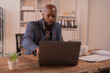 © Tj - Focused businessman working diligently on a laptop in a modern office, managing tasks and enhancing productivity through advanced technology and effective communication
