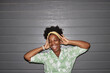 © Seventyfour - Chest up portrait of joyful African American woman wearing casual outfit styled with designer accessories posing with eyes closed and arms raised against grey garage door, camera flash, copy space