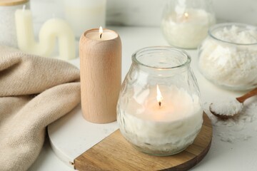 Wall Mural - Burning soy wax candles on light table, closeup