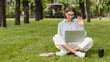 © InsideCreativeHouse - Young caucasian female woman freelancer student blogging vlogging having video call conversation watching webinar remote lection online on laptop outdoors in park on green lawn