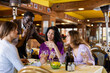 © JackF - African-american man chatting with group of three women in restaurant.