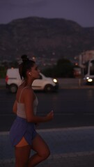 Wall Mural - A woman is jogging energetically in an urban environment during the beautiful dusk hours