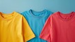 © HISTOCK - Three colorful t-shirts lying on blue background, simple casual clothing banner