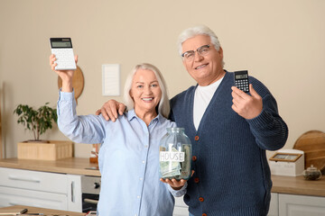 Wall Mural - Senior couple with jar of money for house and calculators in kitchen