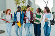 © Jose Calsina - Group of Diverse Students Joyfully Walking and Talking Together While Engaging in Lively Conversation and Sharing Academic Materials at University Campus Filled with Friendship and Laughter