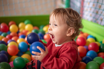 excited baby in ball pool