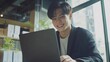 © Ariep - Smiling Young Man Working on Laptop in Modern Office