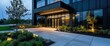 © Design By Reiga - Modern office building entrance at dusk, landscaped grounds. Use Real estate marketing