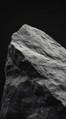 Wall Mural - Close-up of a dark, textured rock against a black background.