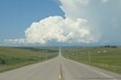 © mohdfaizal - Expansive Road Leading to Distant Storm Clouds Over Green Landscape