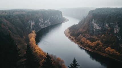 Sticker - Misty river winding through a valley surrounded by autumnal forests.