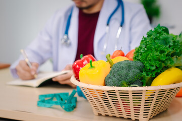 Wall Mural - A male nutritionist sitting at a table, advising on healthy diets, promoting vegetable-based meals, supplements, weight loss, and meal planning to improve overall health and well-being