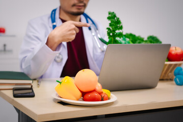 Wall Mural - A male nutritionist sitting at a table, advising on healthy diets, promoting vegetable-based meals, supplements, weight loss, and meal planning to improve overall health and well-being