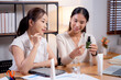 © NT_studio - Two asian businesswoman testing and researching cosmetic product or cream in bottle in office, two business woman creative with planning project design package of skincare, development and business.