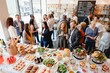 © Rawpixel.com - A diverse group of people at a buffet-style gathering, enjoying food and drinks. The event features a variety of dishes and lively conversation in a bright setting. Diverse people mingle at buffet.