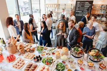 Wall Mural - a diverse group of people at a buffet-style gathering, enjoying food and drinks. the event features 
