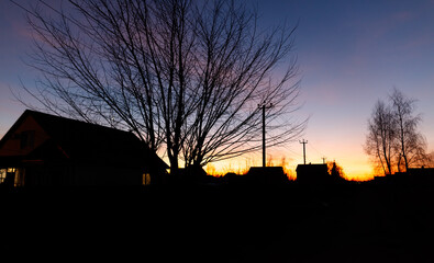 Wall Mural - A house and a tree are silhouetted against a beautiful sunset